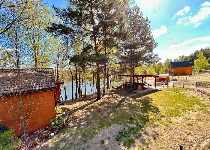 Domek nad jeziorem z łódką i prywatnym pomostem.