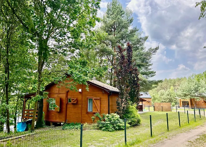 Domek nad jeziorem z łódką i prywatnym pomostem.